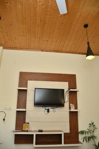 a flat screen tv sitting on top of a wall at Hotel Le Halcyon Kasauli in Solan