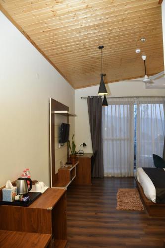a bedroom with a bed and a desk and a television at Hotel Le Halcyon Kasauli in Solan
