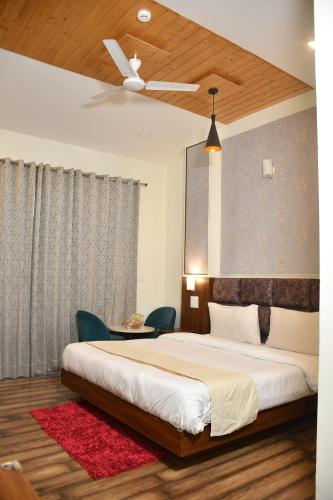 a bedroom with a large bed and a ceiling fan at Hotel Le Halcyon Kasauli in Solan