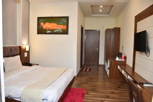 a hotel room with a bed and a flat screen tv at Hotel Le Halcyon Kasauli in Solan