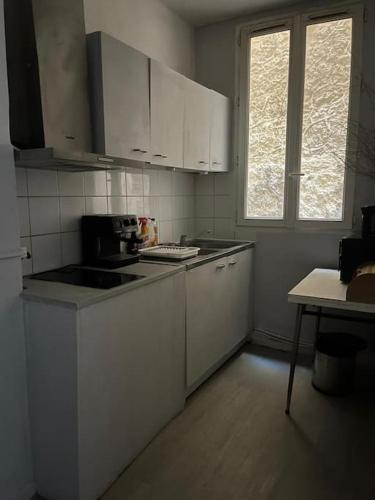 une cuisine avec des armoires blanches et un four à plaques de cuisson dans l'établissement Felix YourHostHelper, à Marseille