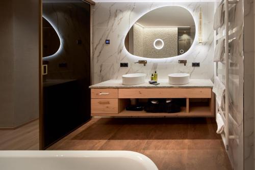 a bathroom with two sinks and a mirror at Hotel Neue Post in Mayrhofen
