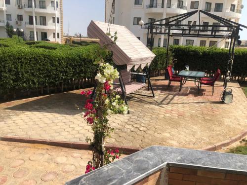 a garden with a table and flowers in a courtyard at Paradise Gates Golden Beach two in Ras Sedr