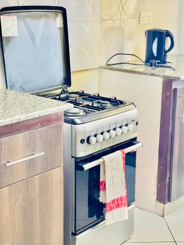 a kitchen with a stove with a towel on the oven at Elna's Nyali - Work & Unwind - Pool, Sea Views, AC & Fast Wi-Fi in Mombasa