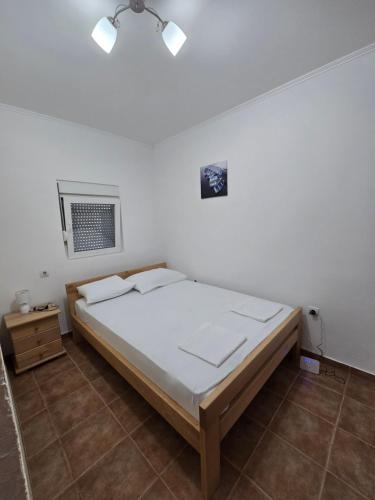 a bedroom with a bed and a white wall at Apartman Turkovic in Herceg-Novi