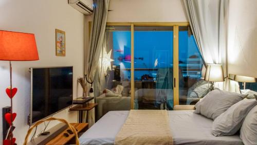 une chambre avec un lit et une grande fenêtre dans l'établissement T2 Climatisé Vue Mer 11ème Etage Avec Accés Plages, à Villeneuve-Loubet