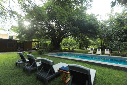 a yard with chairs and a swimming pool at The Waterfront, Maun in Maun