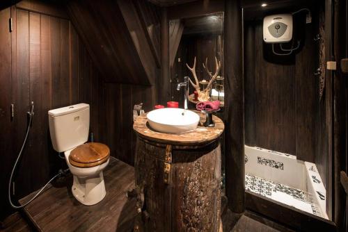 a bathroom with a sink and a toilet at Batak Legacy, A Jungle Hideaway in Tabanan