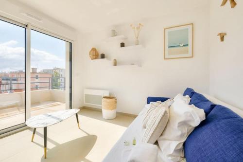 un salon avec un canapé bleu et une fenêtre dans l'établissement T2 avec Terrasse et Parking privé au coeur de Nice, à Nice