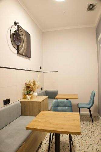 a room with two tables and a clock on the wall at Five's Hotel Astana in Astana