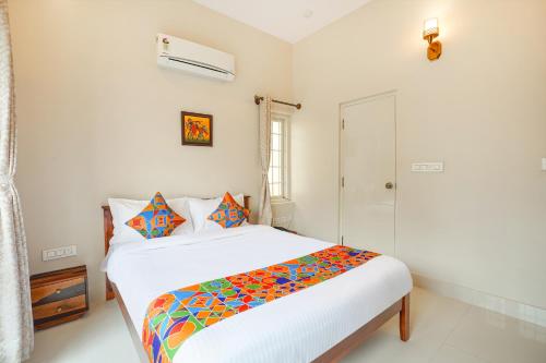 a white bedroom with a bed and a shower at FabHotel Bougainvillea Suites - Horamavu in Bengaluru