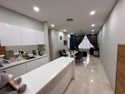 a kitchen and living room with a table and chairs at Sky Suites at KLCC by Mitstay in Kuala Lumpur