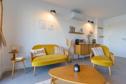 un salon avec deux chaises et une table dans l'établissement L'Ostra - Maison sur l'eau proche Arcachon, à Gujan-Mestras