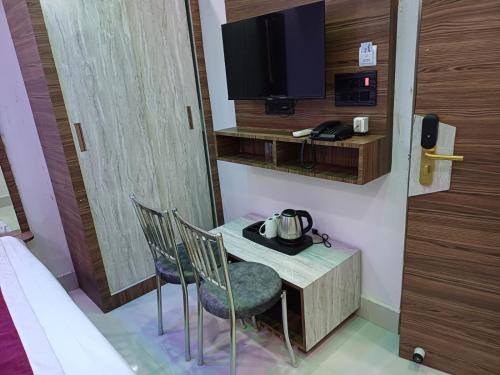 a room with a table and chairs and a tv at Hotel Shobhani in Deoghar