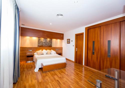 a large bedroom with a bed and wooden floors at Hotel Rusadir in Melilla