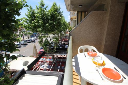 a balcony with a table and chairs and a street at Basic Comfort Studio POBLAT TIPIC 0167 in Empuriabrava