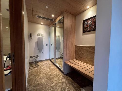 a bathroom with two urinals and a bench in it at Ramada by Wyndham Aligarh GT Road in Alīgarh