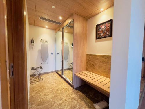 a bathroom with a shower and a bench in it at Ramada by Wyndham Aligarh GT Road in Alīgarh