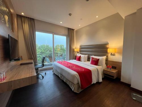 a hotel room with a bed and a large window at Ramada by Wyndham Aligarh GT Road in Alīgarh