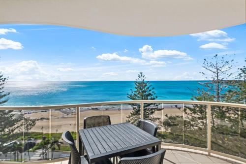 a balcony with a table and a view of the beach at Zanzibar 905, Ocean front 2 bedroom apartment in Mooloolaba
