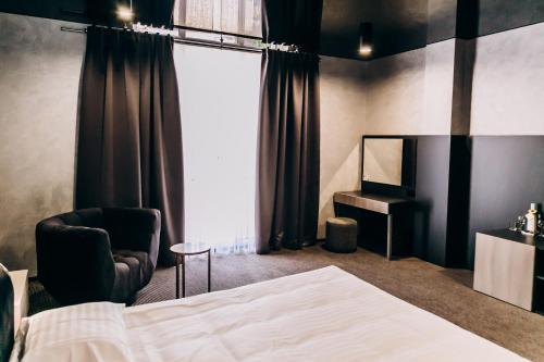 a bedroom with a bed and a chair and a desk at Optima Collection Chernivtsi in Chernivtsi