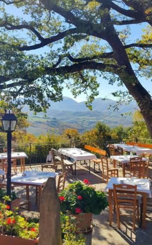 a group of tables and chairs under a tree at Agriturismo Roccamaia in Pievebovigliana