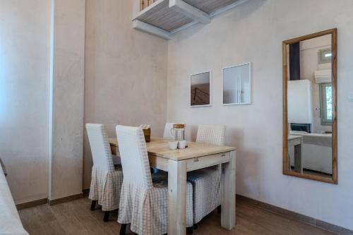 a dining room with a table and chairs and a mirror at Chroma Pelion Villas in Kato Gatzea