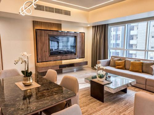 Una sala de estar con un sofá y un televisor en Royal Home, en Abu Dabi