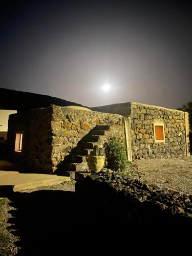 a stone building with stairs on the side of it at La Grotta di benikula' in Pantelleria