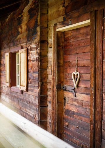 a door with a heart on the side of a building at Flasswiesen Alm in Lienz