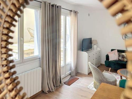 a living room with a large window and a couch at Le Antoinette in Compiègne
