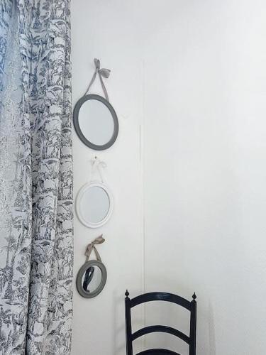 a chair and two round mirrors on a wall at Le Antoinette in Compiègne