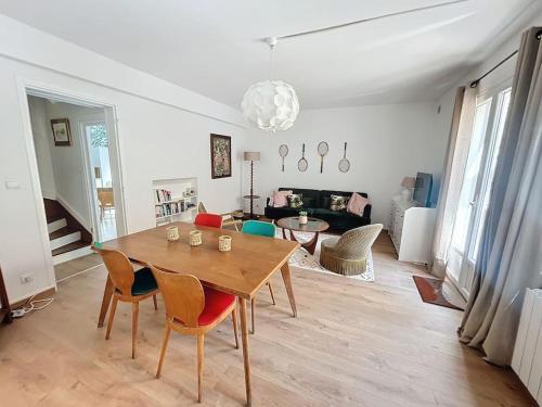 a living room with a wooden table and chairs at Le Antoinette in Compiègne