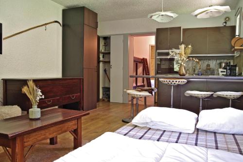 une chambre avec un lit, un bureau et une table dans l'établissement Au calme entre les mélèzes- Appt proche des pistes, aux Orres
