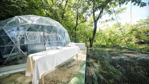 a table in a glass igloo in a garden at Domos Mirador Romantic Private Honeymoon Glamping in Miramar