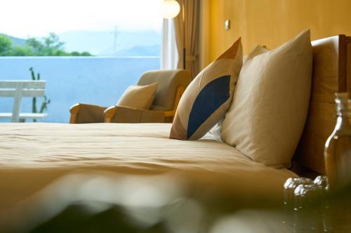 a bedroom with a bed with pillows and a window at OwlStay Green Villa in Pinghe