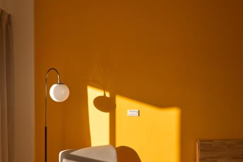 a room with a lamp and a yellow wall at OwlStay Green Villa in Pinghe