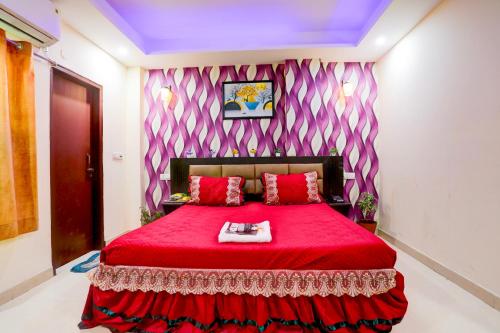 a bedroom with a red bed with a red blanket at HOTEL GLOBAL STAY NEAR DELHI AiRPORT in New Delhi