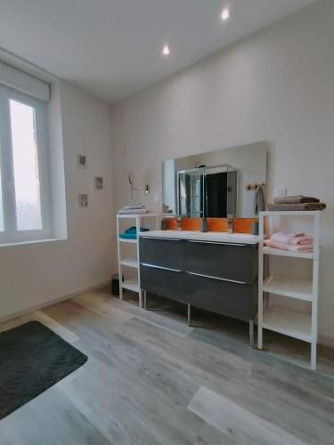 a kitchen with a sink and a large mirror at L'école buissonnière in Laroque-dʼOlmes