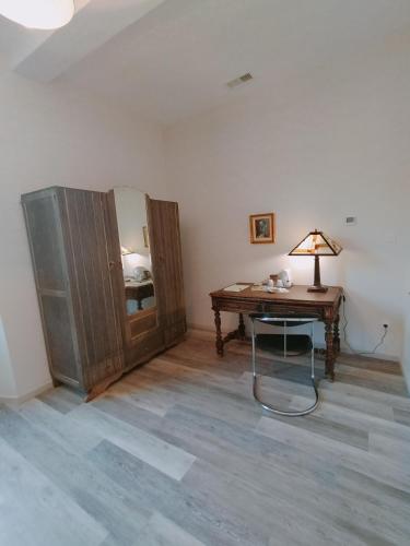 a room with a desk and a lamp on a table at L'école buissonnière in Laroque-dʼOlmes