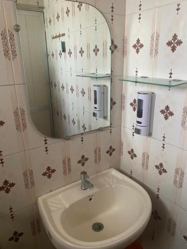 a bathroom with a sink and a mirror at Baga Beach Palms in Baga