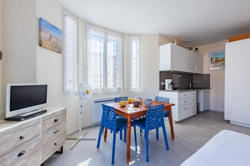une cuisine avec une table et des chaises et une télévision dans l'établissement Studio de la Villa - Welkeys, à Bandol
