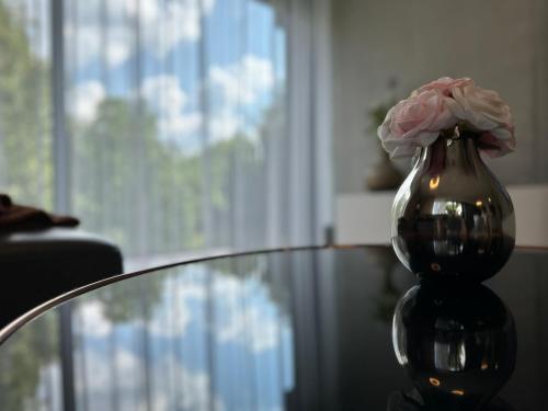 a vase with a flower in it sitting on a table at 3D Park Living Apartment in Žilina