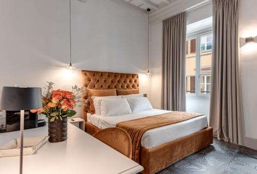 a bedroom with a bed and a table with a vase of flowers at Magia di Firenze in Florence