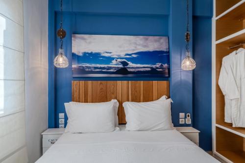 a bedroom with blue walls and a bed with white pillows at Chroma Pelion Villas in Kato Gatzea