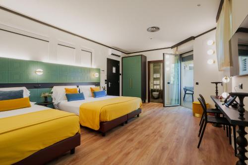 a hotel room with two beds with yellow and blue pillows at JOIVY Together Florence Urban Resort in Florence