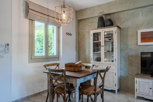 a dining room with a wooden table and chairs at Chroma Pelion Villas in Kato Gatzea
