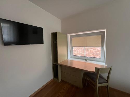 a room with a desk and a window and a chair at 1912 Bed & Breakfast in Klaipėda