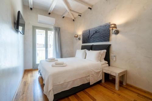 a bedroom with a large bed with white sheets at Chroma Pelion Villas in Kato Gatzea