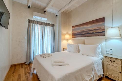 a bedroom with a large white bed and a window at Chroma Pelion Villas in Kato Gatzea